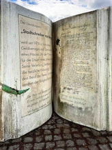 Bild: Ein steinernes Buch, gewidmet den Stadtschreibern von Bergen-Enkheim