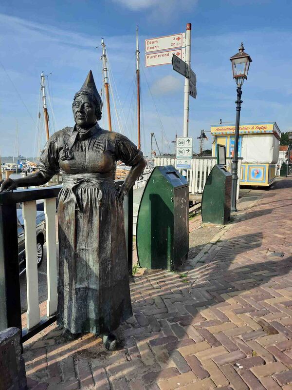 Frau Antje steht am Hafen von Volendam,